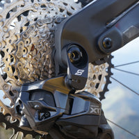 ShimanoDi2 Cambio posteriore su una mountain bike elettrica Rotwild R.EX900 Eightpins Supporto per deragliatore posteriore Stiffshifter UDH e motore DJi di fronte a uno splendido scenario montano.